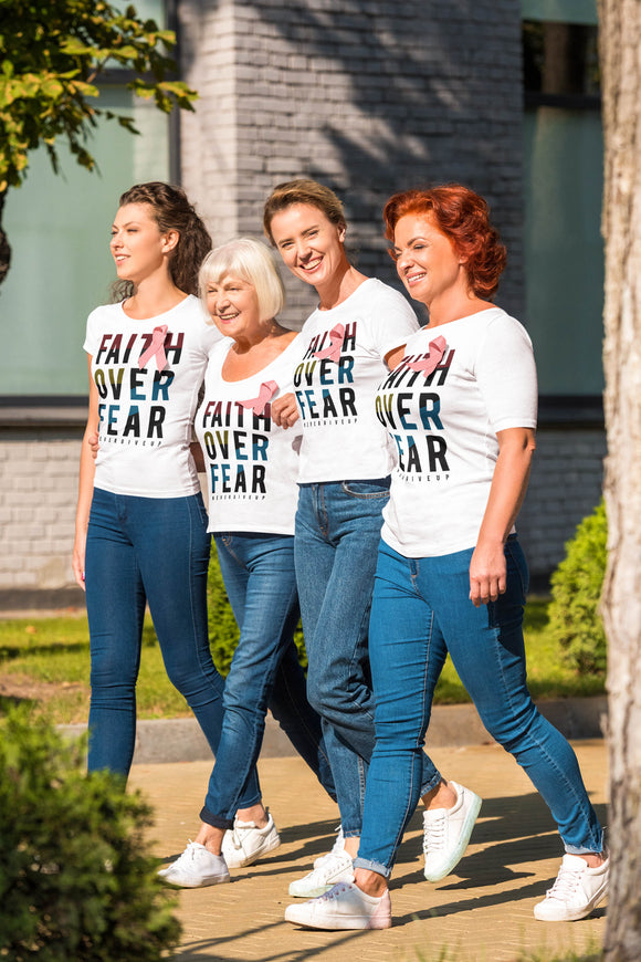 Four women walking for breast cancer awareness wearing white t-shirts with the message Faith Over Fear.